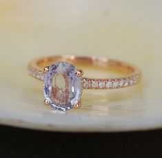 an oval shaped tan and white diamond ring on a shell with diamonds around the band