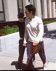 two men walking down the street with one holding his hand on another's hip