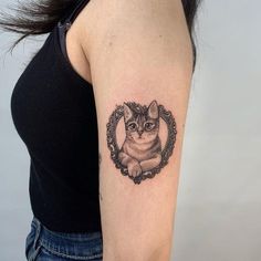 a woman with a cat tattoo on her arm and the image is in a frame