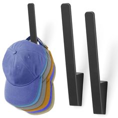 a hat rack with five hats hanging from it's sides next to a pair of baseball caps