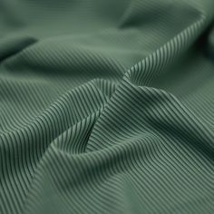 the texture of a green fabric is very close to it's surface and folds