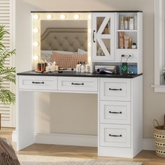 a white vanity with lights on it in a room next to a bed and potted plant