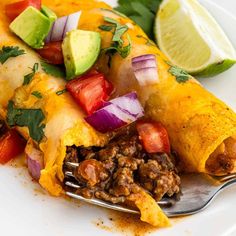 an enchilada on a plate with a fork