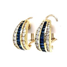 90s fashion inspiration with Modern glam. These chubby hoop earrings feature blue sapphires and diamonds in 18 karat yellow gold. Twenty-eight (28) baguette cut dark blue sapphires decorate the centers of the hoops. A collection of near colorless diamonds hug the sapphires on all sides. Finished on tapered 18 karat yellow gold hoops. A gorgeous set of earrings in blue sapphire and diamonds. Luxury Small Hoop Blue Jewelry, Luxury Gemstone Hoop Jewelry, 90s Fashion Inspiration, Modern Glam, Colorless Diamond, Metal Shop, Diamond Hoop Earrings, Shop Engagement Rings, Baguette Cut