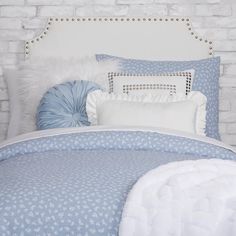 a white and blue bed with pillows on it