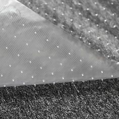 a black and white photo of an umbrella with raindrops on the ground in front of it