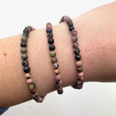 This listing is for one (1) rhodonite bracelet. These are stock photos in which you will be hand selected a bracelet. You will receive one that is similar to the ones pictured.  These are one size: "one size fits all" These are best suited for wrists measuring 5.5-7 inches in diameter. They do stretch quite a bit past that as well (if needed). (I have quite small wrists and they fit me fine, they are not too loose though; my wrists are shown in the picture). They are strung on elastic string in order to fit almost any wrist size!  Chip Style: these are round beads Stone size: 3-4mm Each order is packaged with love and care. If you have any questions feel free to message me! Rhodonite Bracelet, Rainbow Fluorite, Smoky Quartz, Round Beads, One Pic, Matrix, One Size Fits All, Jewelry Bracelets, Etsy Accessories