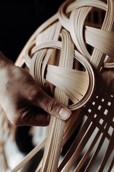 a person is making a wooden chair out of strips of plywood and some sort of wire