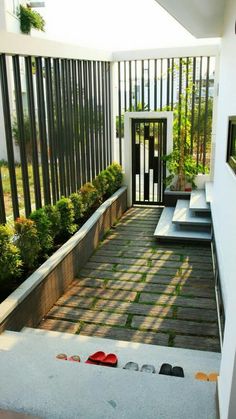 an open door leading into a small courtyard with steps and plants on the side walk