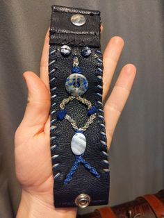 This is a unique leather cuff bracelet made from upcycled leather. It is accented with blue and white macrame, lapis lazuli and lace agate. It is 6.5 inches long and 1.75 inches wide.  I got this leather when I visited a leather shop in rural nevada. I told them that I liked to do leather work and they gave me cuts from chaps they had sold to bikers and shortened for them. I'm happy to give this leather a second life! Upcycled Leather, Leather Cuff Bracelet, Macrame Bracelet, Leather Cuffs Bracelet, Leather Work, Macrame Bracelets, Leather Shops, Leather Cuffs, Lace Agate