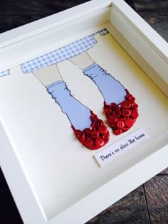 two pairs of red shoes are in a shadow box