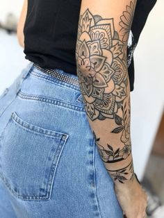 a woman with a flower tattoo on her arm and back half - sleeved shirt