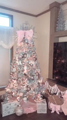 a white christmas tree with pink and silver ornaments