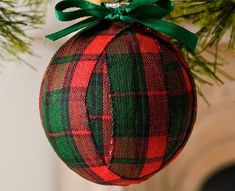 an ornament hanging from a christmas tree with green and red plaid fabric on it