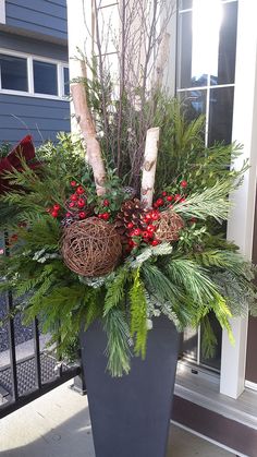 a planter filled with evergreen and red berries