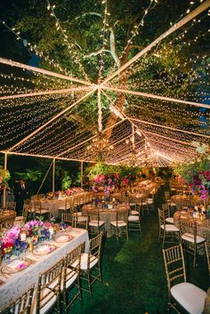 the inside of a tent with tables and chairs set up for an outdoor wedding reception