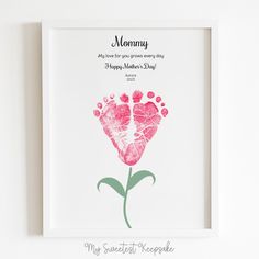 a mothers day card with a pink flower in the shape of a handprinted heart