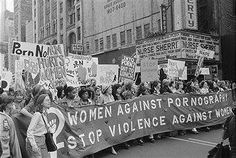 a group of women marching down the street with signs and banners on their backs as they march