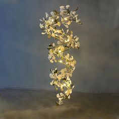 a chandelier with flowers hanging from it's sides on a gray background