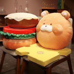 a large stuffed animal sitting on top of a chair next to hamburgers and cheese