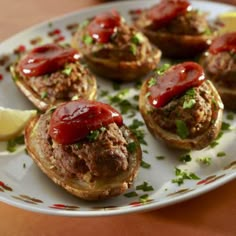 small sandwiches with ketchup and lemon wedges on a plate