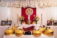 the altar is decorated with flowers, candles and pictures in gold vases on it