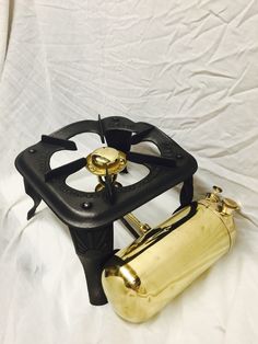 an old fashioned propane stove on a white sheet with the top open and it's burners exposed