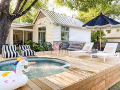 an inflatable toy floats on the deck of a backyard with lounge chairs and umbrellas