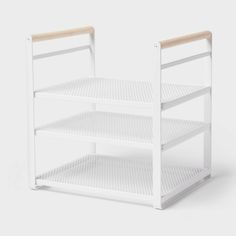 a white shelf with two shelves on each side and one shelf in the middle, against a white background