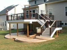 a deck with steps leading up to the upper level and an attached balcony above it