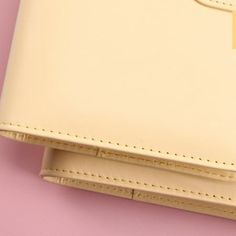 two pieces of white leather on top of each other with a yellow tag attached to it