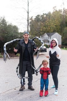 a man, woman and child are dressed up as spider - man in the street