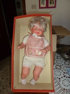 an old doll in a box on a table