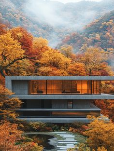 the house is surrounded by colorful trees and mountains in autumn time, with fog coming from the windows