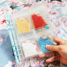 a person holding a plastic container filled with beads