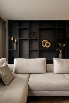 a white couch sitting in front of a book shelf