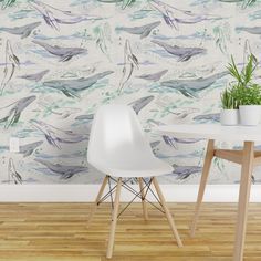 two white chairs and a table in front of a wallpapered background with dolphins