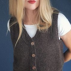 a woman with blonde hair wearing a brown sweater vest