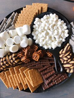 a platter filled with marshmallows, pretzels and crackers