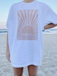 "The PERFECT summer graphic tee! Comfort Colors white t-shirt with a sun design. Model is 5'4\" and wearing a size XL for an oversized look. 100% cotton." White Crew Neck T-shirt For Summer, White Screen Print T-shirt For Summer, Summer Graphic Tee With Front Print, White Cotton Summer T-shirt, Summer Crew Neck T-shirt With White Print, Summer White Top With Screen Print, White Summer Top With Screen Print, White T-shirt For Summer, Oversized White Print Summer Tops