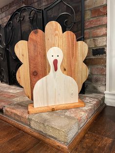 a wooden turkey sitting in front of a fireplace