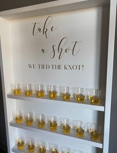 there is a shelf with glasses on it that says take a shot we tied the knot