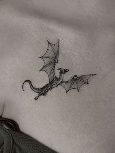 a black and white photo of a dragon tattoo on the side of a woman's stomach