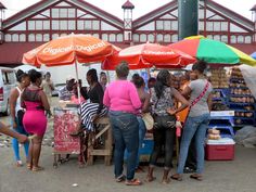 people standing under umbrellas at an outdoor market