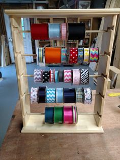 several rolls of different colored ribbons are on display in a shop with wooden shelves and shelving