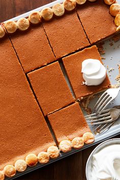 a pie is cut into squares and ready to be served with whipped cream on the side