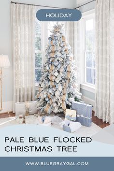 a blue flocked christmas tree with presents under it and the words holiday pale blue flocked christmas tree