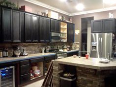 a kitchen with black cabinets and stainless steel appliances in the center, along with granite counter tops