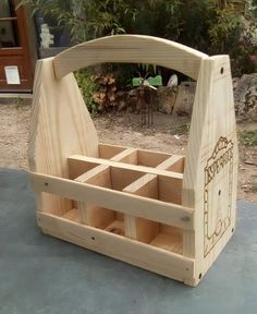 a wooden box with compartments in the middle on a table next to some plants and trees