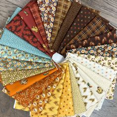 a bunch of different types of fabric on a wooden table with a computer mouse in the middle